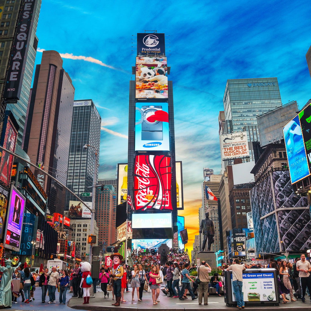 Times Square in all it's glory. Moving billboards advertising shows and Coca Cola and people on the streets.